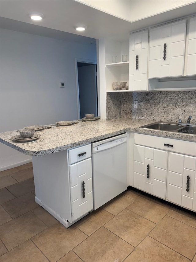 kitchen featuring dishwasher, white cabinetry, tasteful backsplash, light stone countertops, and kitchen peninsula