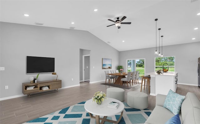 living room featuring ceiling fan, sink, light wood-type flooring, and high vaulted ceiling