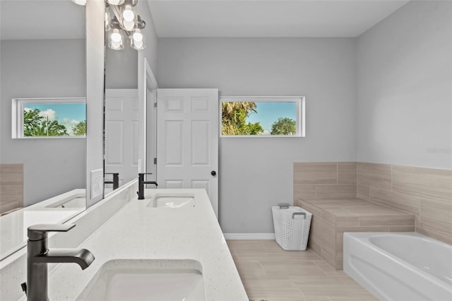 220 Mark Twain Ln, Rotonda West, FL 33947 - bathroom with a sink, baseboards, a garden tub, and double vanity