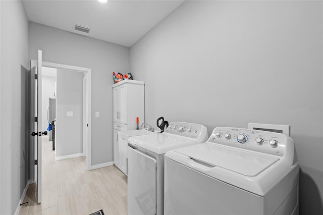 220 Mark Twain Ln, Rotonda West, FL 33947 - laundry room with visible vents, baseboards, cabinet space, and washing machine and dryer