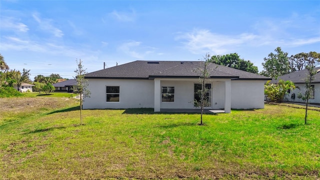 220 Mark Twain Ln, Rotonda West, FL 33947 - rear view of house featuring a lawn, roof with shingles, and stucco siding