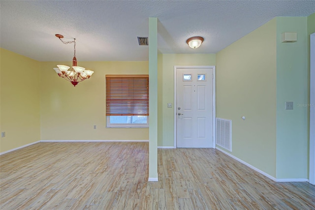 612 Deerwood Ave Unit 169, Englewood, FL 34223 - foyer featuring light wood-type flooring, a textured ceiling, a chandelier, and baseboards