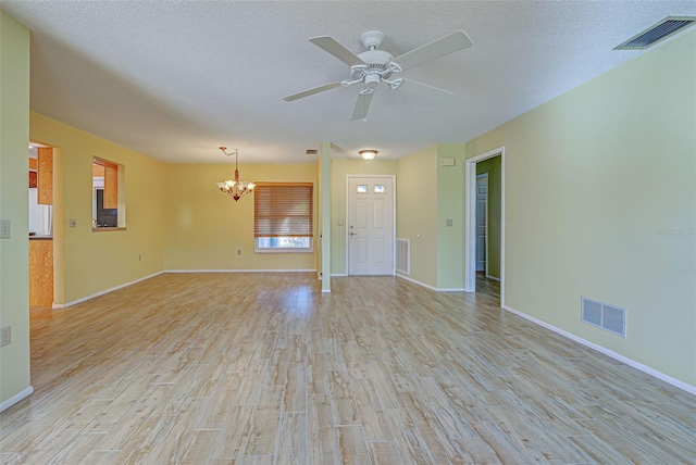 unfurnished living room featuring light hardwood / wood-style floors, a textured ceiling, and ceiling fan with notable chandelier