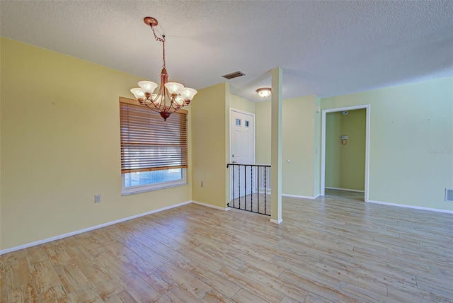 612 Deerwood Ave Unit 169, Englewood, FL 34223 - unfurnished room featuring a chandelier, a textured ceiling, wood finished floors, and baseboards
