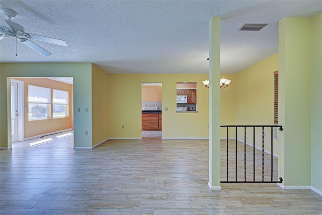 unfurnished room featuring light hardwood / wood-style flooring, a textured ceiling, and ceiling fan