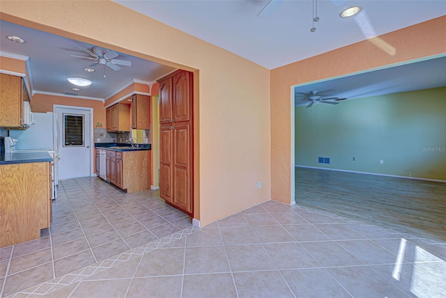 kitchen with backsplash, sink, crown molding, light tile patterned floors, and white appliances