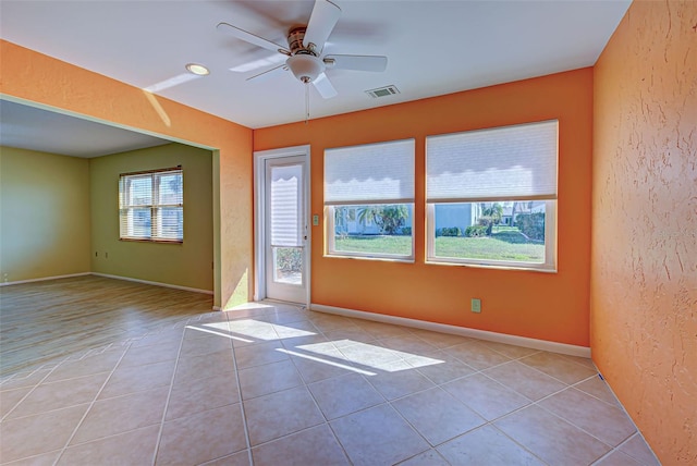 tiled spare room with ceiling fan