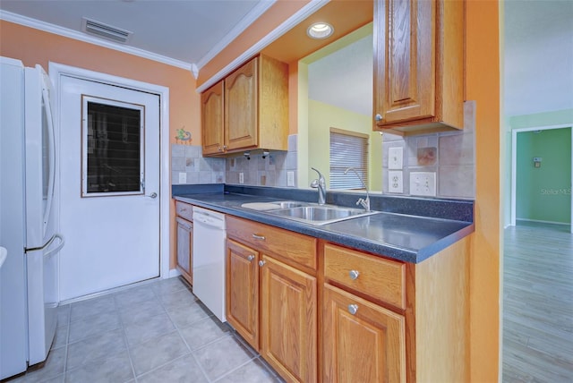 kitchen featuring white appliances, sink, backsplash, ornamental molding, and light tile patterned floors