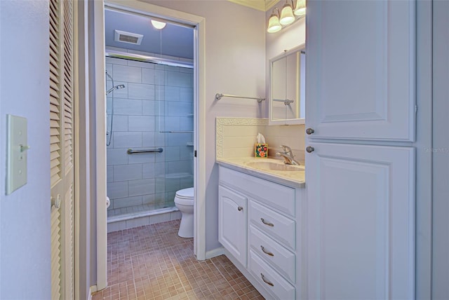 bathroom featuring a shower with door, vanity, toilet, and tile patterned floors