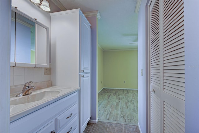 bathroom with hardwood / wood-style floors, vanity, and crown molding