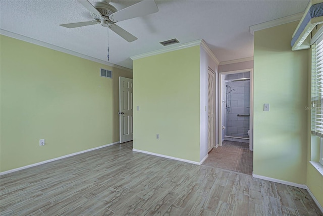 interior space featuring connected bathroom, a closet, ornamental molding, light hardwood / wood-style floors, and ceiling fan