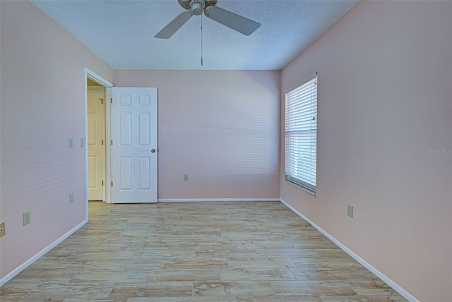 empty room with light hardwood / wood-style floors, a textured ceiling, and ceiling fan