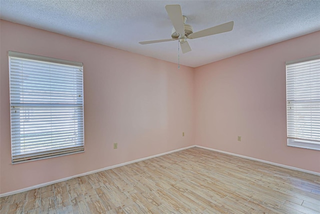 empty room featuring light hardwood / wood-style floors, plenty of natural light, and ceiling fan