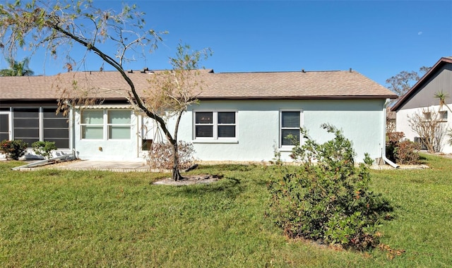 612 Deerwood Ave Unit 169, Englewood, FL 34223 - back of house featuring a lawn, stucco siding, and roof with shingles