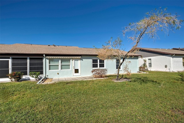612 Deerwood Ave Unit 169, Englewood, FL 34223 - rear view of house with a lawn, stucco siding, and roof with shingles