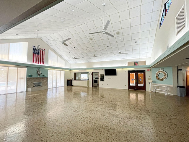 612 Deerwood Ave Unit 169, Englewood, FL 34223 - miscellaneous room featuring a towering ceiling, ceiling fan, a paneled ceiling, a fireplace, and speckle patterned floor