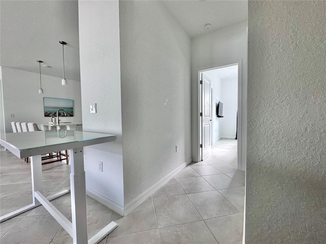 corridor featuring sink and light tile patterned floors