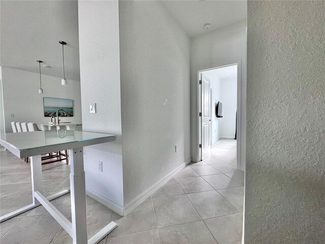 19060 Moscato Ct, Venice, FL 34293 - corridor with a textured wall, light tile patterned floors, a sink, and baseboards