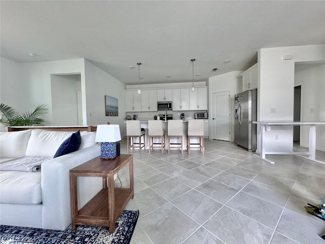 living room with a textured ceiling and light tile patterned flooring