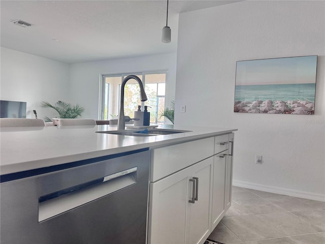 kitchen featuring sink, white cabinetry, pendant lighting, stainless steel dishwasher, and light tile patterned floors