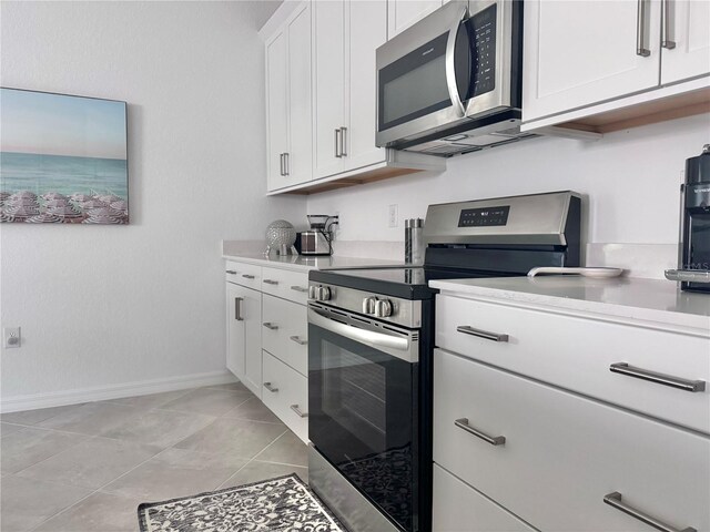 19060 Moscato Ct, Venice, FL 34293 - kitchen with appliances with stainless steel finishes, light countertops, white cabinetry, and baseboards