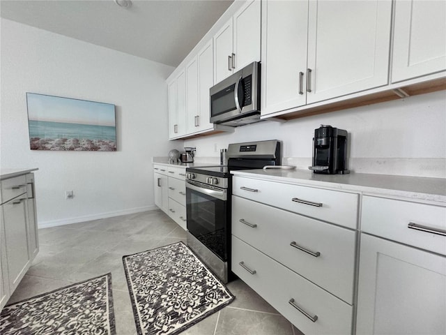 kitchen featuring appliances with stainless steel finishes, white cabinetry, and light tile patterned flooring