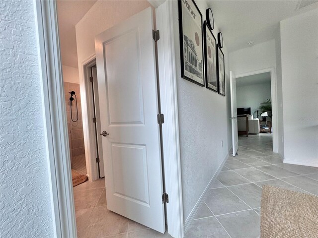 19060 Moscato Ct, Venice, FL 34293 - hallway featuring light tile patterned floors, a textured wall, and baseboards