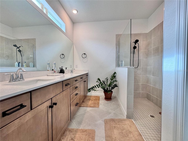 bathroom featuring vanity, a tile shower, and tile patterned flooring