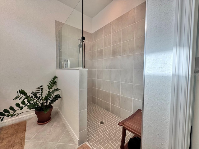 bathroom featuring tiled shower and tile patterned flooring