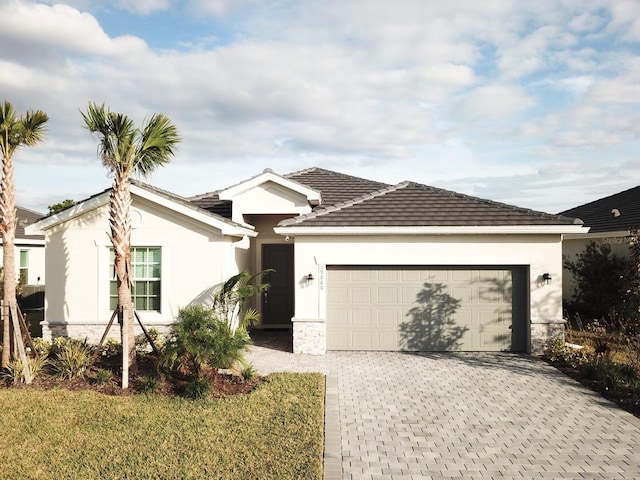 19060 Moscato Ct, Venice, FL 34293 - ranch-style home with stucco siding, an attached garage, decorative driveway, stone siding, and a tiled roof
