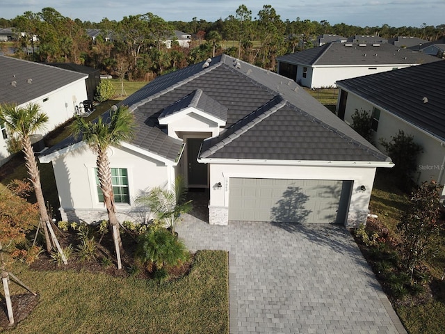 19060 Moscato Ct, Venice, FL 34293 - ranch-style house featuring a garage, decorative driveway, stucco siding, and a tile roof
