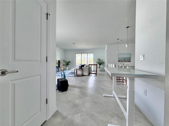19060 Moscato Ct, Venice, FL 34293 - corridor with a sink, a textured ceiling, light tile patterned floors, and baseboards