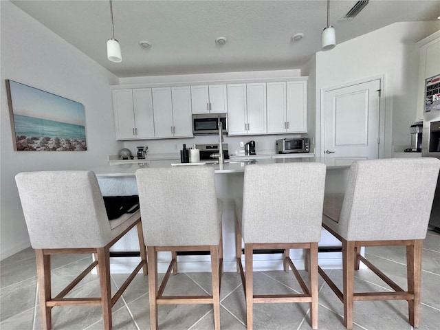 19060 Moscato Ct, Venice, FL 34293 - kitchen featuring stainless steel microwave, decorative light fixtures, light countertops, and range