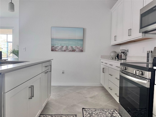 19060 Moscato Ct, Venice, FL 34293 - kitchen with appliances with stainless steel finishes, light countertops, baseboards, white cabinets, and a sink