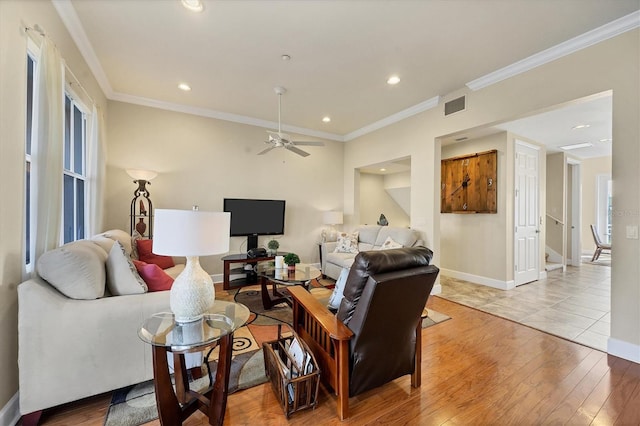 living room featuring ornamental molding, ceiling fan, and light wood-type flooring