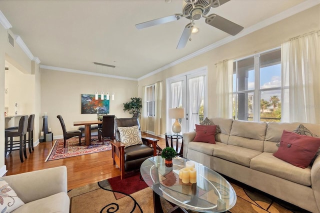 living room with crown molding, hardwood / wood-style flooring, and ceiling fan