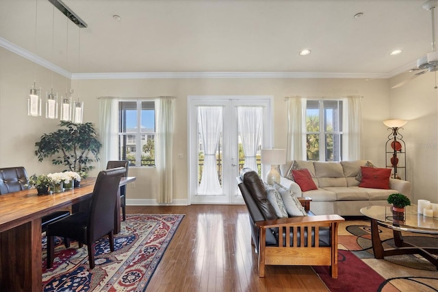 living room featuring hardwood / wood-style flooring, ornamental molding, plenty of natural light, and ceiling fan