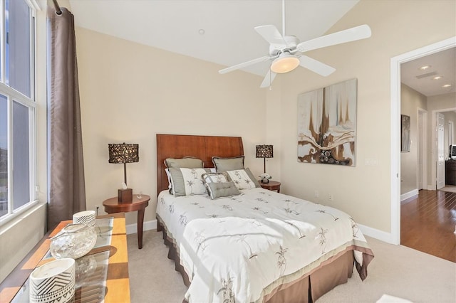 bedroom with lofted ceiling, light carpet, and ceiling fan