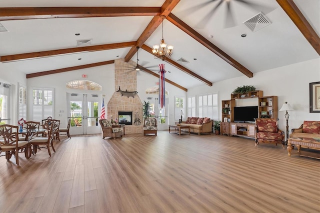 living room featuring light hardwood / wood-style flooring, beam ceiling, high vaulted ceiling, a multi sided fireplace, and a notable chandelier