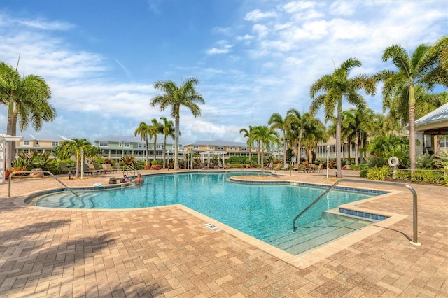 view of swimming pool featuring a hot tub and a patio