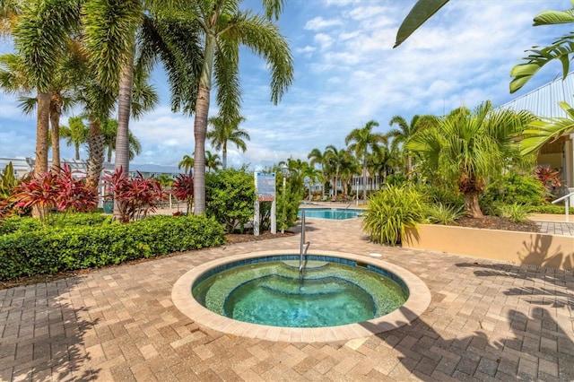 view of swimming pool with a community hot tub and a patio