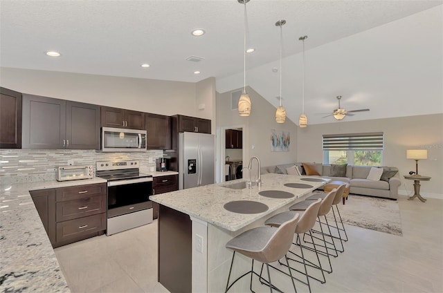 2775 Wyola Ave, North Port, FL 34286 - kitchen featuring a kitchen breakfast bar, dark brown cabinets, appliances with stainless steel finishes, and a sink