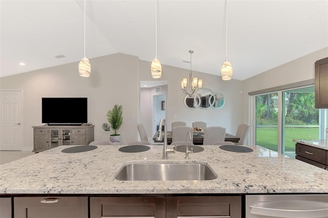 2775 Wyola Ave, North Port, FL 34286 - kitchen featuring light stone countertops, a sink, vaulted ceiling, hanging light fixtures, and an island with sink