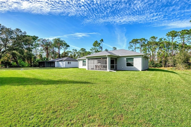 rear view of property featuring a sunroom and a lawn