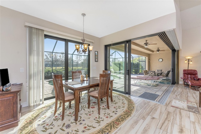 dining space with ceiling fan with notable chandelier and light wood-type flooring