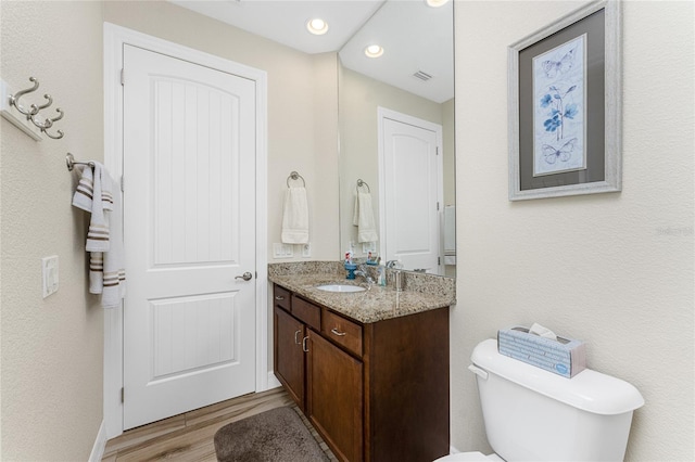 bathroom featuring vanity, hardwood / wood-style floors, and toilet