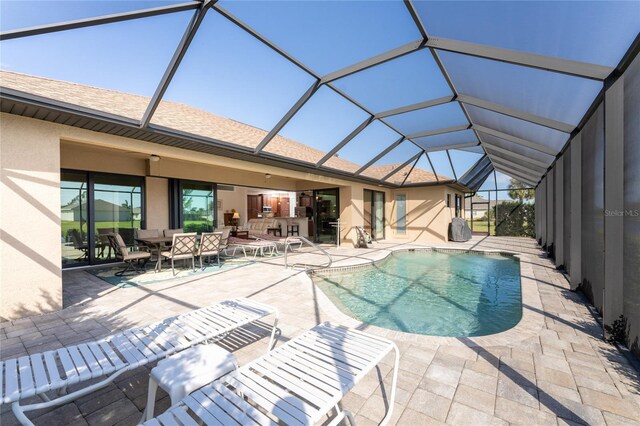 view of swimming pool featuring a patio and glass enclosure