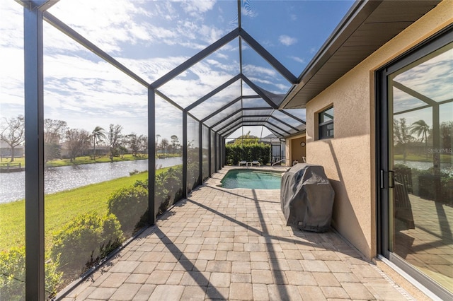 view of patio / terrace featuring a water view and glass enclosure