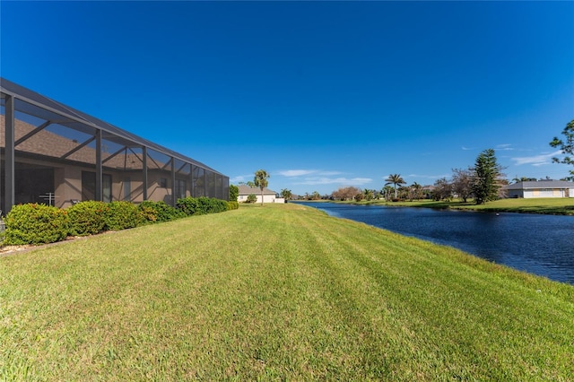 view of yard featuring a water view and glass enclosure