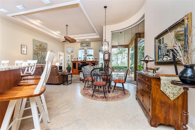 dining area featuring ceiling fan and a tray ceiling